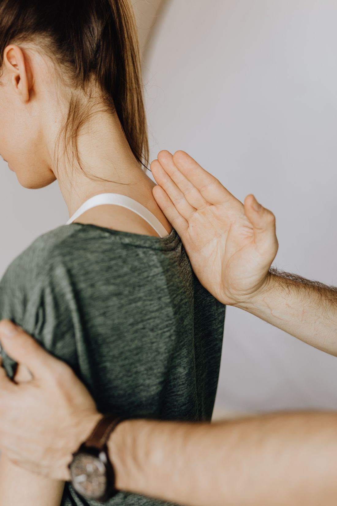 Mano de terapeuta sobre el omóplato de un paciente durante un ajuste